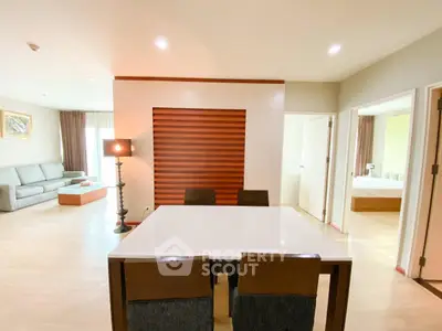 Spacious modern living room with elegant dining area and cozy bedroom view.