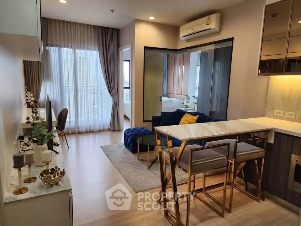 Modern living room with elegant decor and open layout, featuring a stylish dining area and large windows.