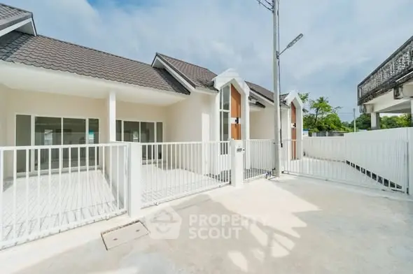 Modern single-story house with gated entrance and spacious driveway.