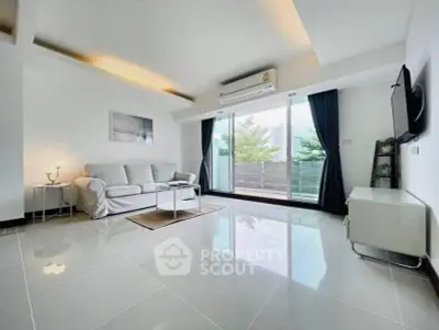 Spacious modern living room with large windows and balcony access