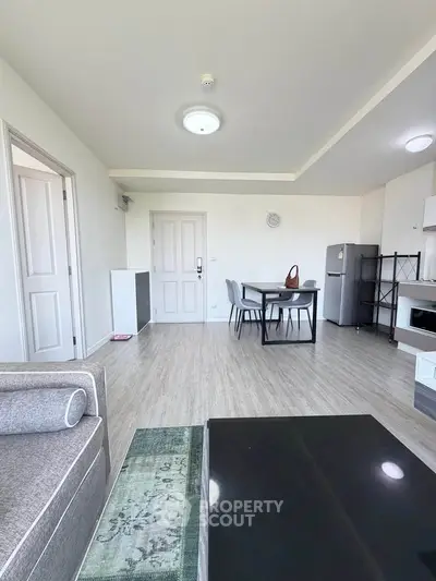 Spacious modern living room with dining area and sleek furniture in a bright apartment.