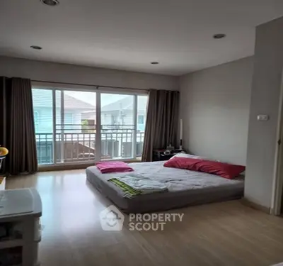 Spacious bedroom with balcony access and natural light in modern home.