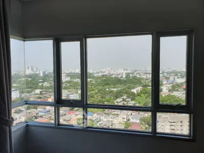 Spacious high-rise corner unit with expansive city views through large windows, offering a bright and airy living space.