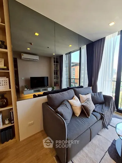 Modern living room with cozy sofa and large windows offering city views