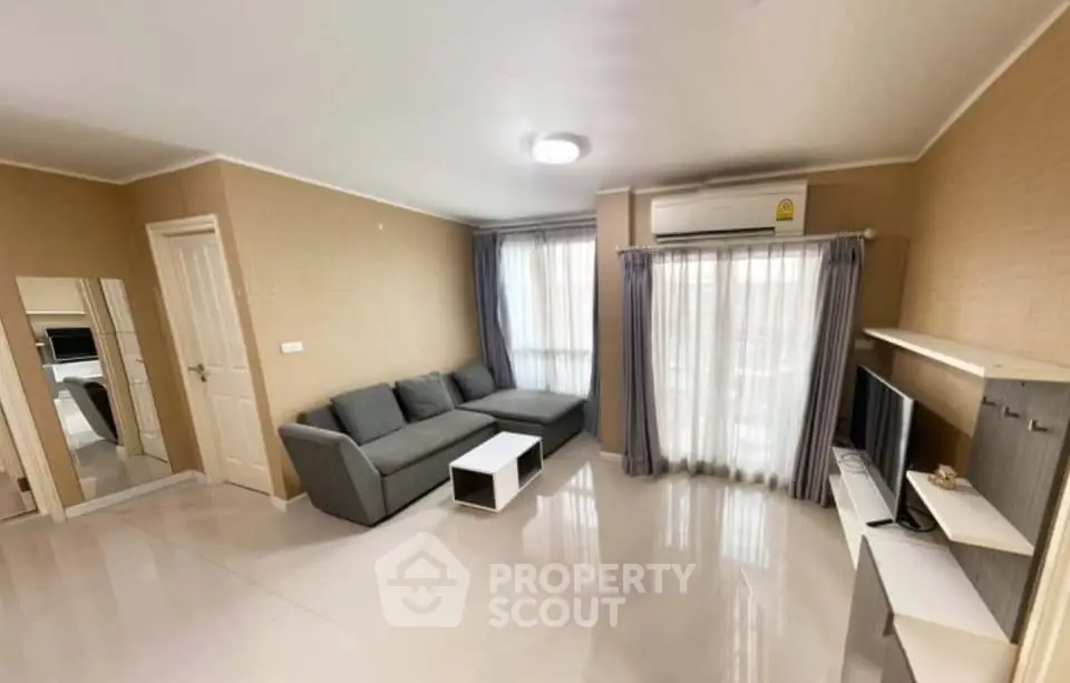 Spacious living room with modern gray sofa and natural light