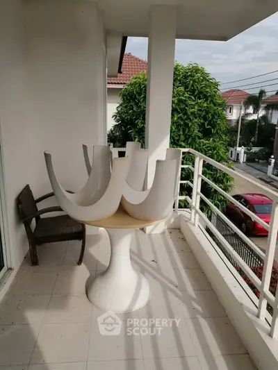 Spacious balcony with modern furniture and scenic neighborhood view.