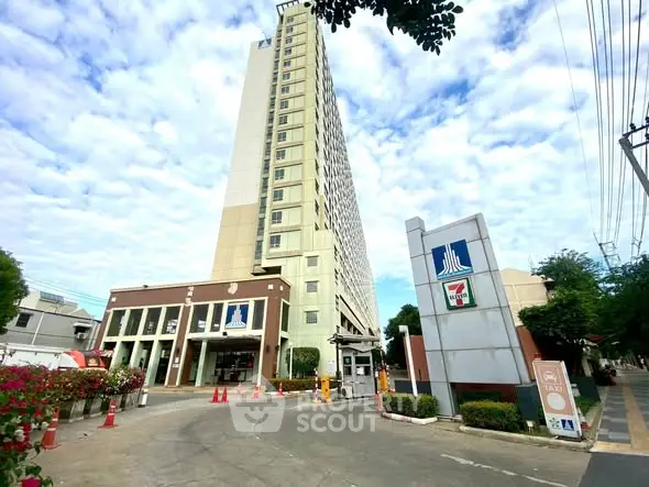 Modern high-rise building with clear sky and entrance signage, ideal for urban living.