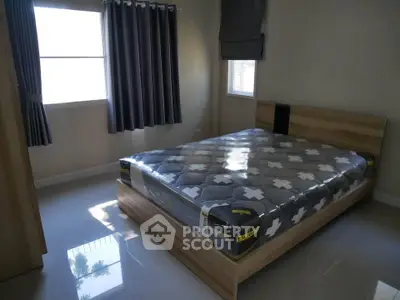 Modern bedroom with sleek design and natural light, featuring a stylish bed and elegant curtains.
