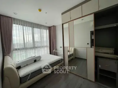 Modern bedroom with large window and mirrored wardrobe in stylish apartment