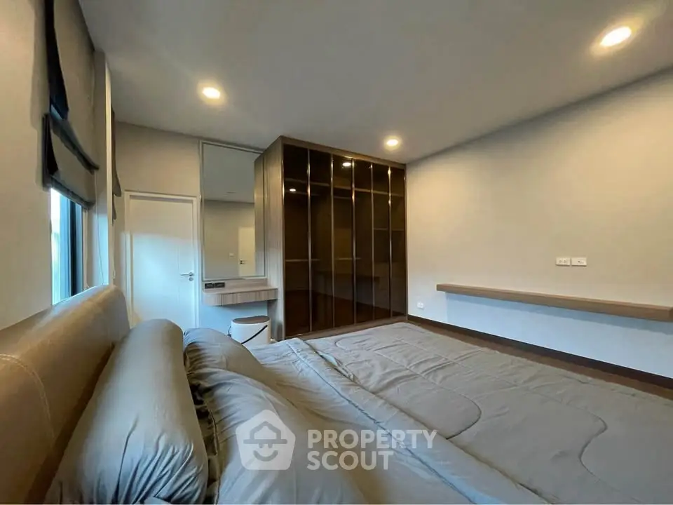 Spacious modern bedroom with sleek built-in wardrobe and cozy lighting