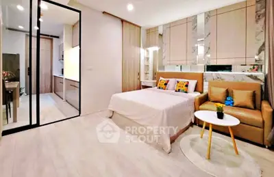 Modern bedroom with stylish decor and open layout leading to kitchen area.