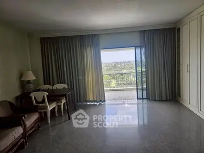 Spacious living room with large windows and balcony view