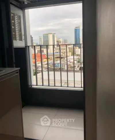 City view from a small balcony in a high-rise apartment, showcasing urban skyline.
