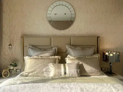 Luxurious bedroom with elegant decor and plush bedding, featuring a stylish mirror and ambient lighting.