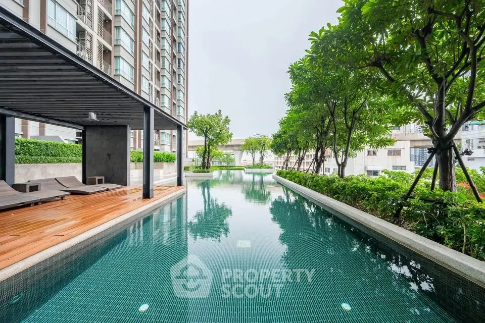 Luxurious condominium pool area with lush greenery and modern design.