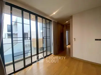 Modern interior hallway with large windows and wooden flooring in a contemporary home.