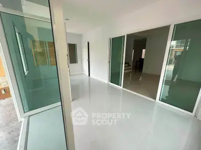 Spacious modern interior with sliding glass doors and sleek tile flooring, perfect for open living spaces.