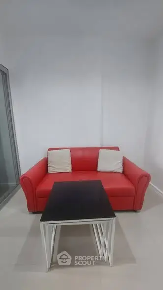 Modern living room with red sofa and sleek coffee table in minimalist design.