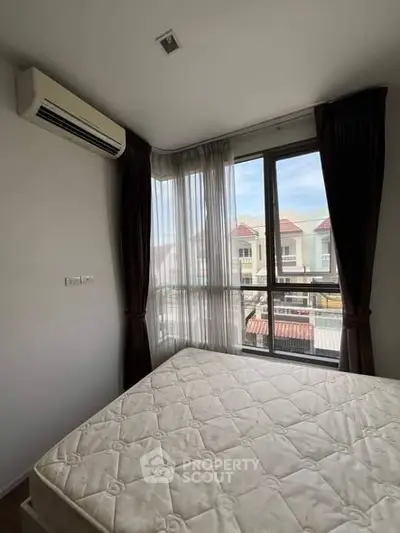 Bright bedroom with large window and air conditioning, offering a cozy and comfortable living space.