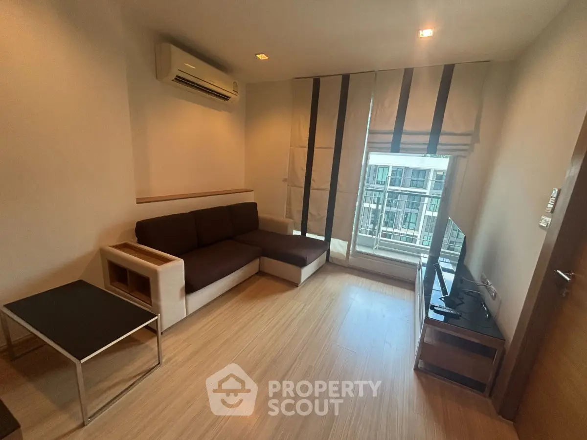Modern living room with sleek furniture and large window in a stylish apartment.