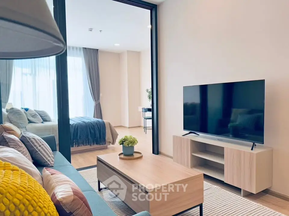 Modern living room with sleek TV setup and cozy bedroom view