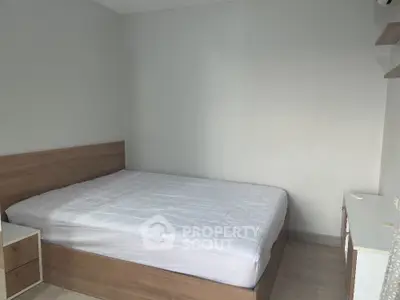 Modern minimalist bedroom with wooden bed frame and white bedding