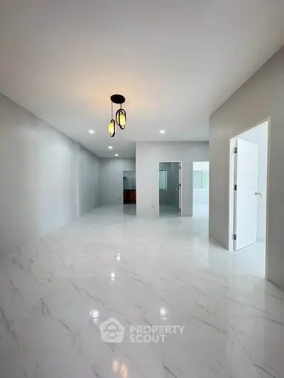 Spacious modern living room with marble flooring and elegant lighting, perfect for stylish urban living.