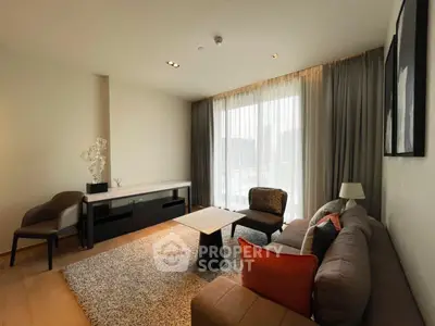 Modern living room with stylish furniture and large window offering natural light.