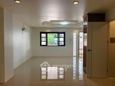 Spacious empty room with glossy tiled floor and large window view