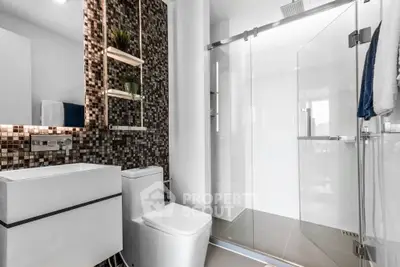 Modern bathroom with sleek design, glass shower, and stylish mosaic tiles.