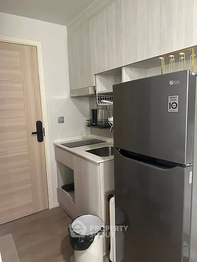 Modern compact kitchen with sleek appliances and wooden cabinetry