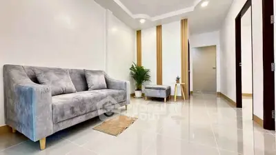 Modern living room with sleek grey sofa and glossy tiled floor
