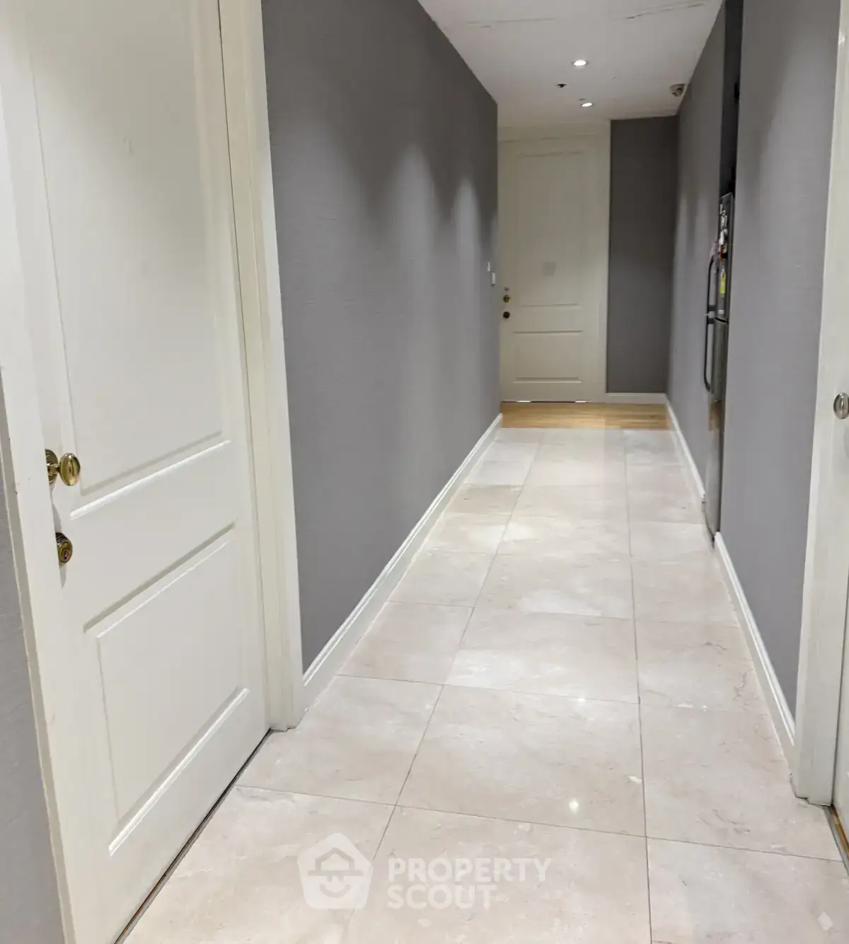 Elegant hallway with marble flooring and modern design in upscale apartment building.