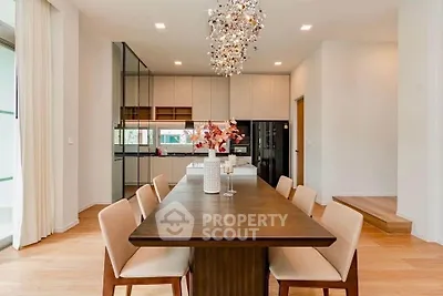 Elegant dining area with modern chandelier and open kitchen layout in a stylish home.