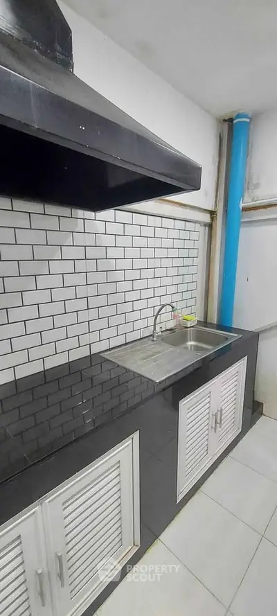 Modern kitchen with sleek black countertops and white subway tile backsplash