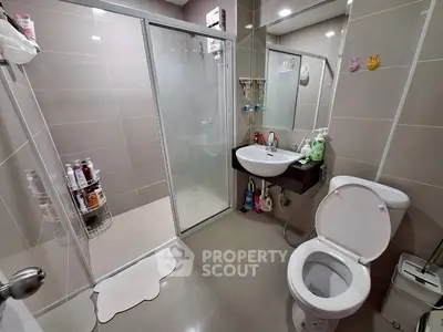 Modern bathroom with glass shower and sleek fixtures in stylish home.