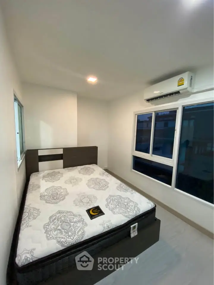 Modern bedroom with large windows and air conditioning unit