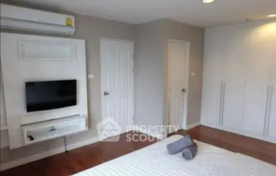 Modern bedroom with wall-mounted TV and sleek wardrobe