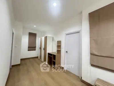 Spacious bedroom with wooden flooring and modern wardrobe design.