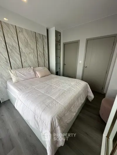 Cozy bedroom with modern decor and soft lighting, featuring a comfortable bed and stylish flooring.