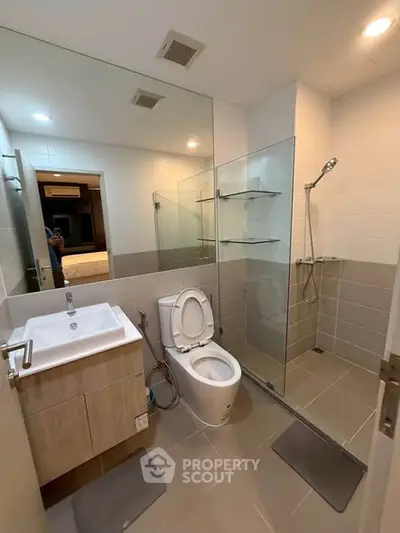 Modern bathroom with glass shower and sleek fixtures in a contemporary apartment.