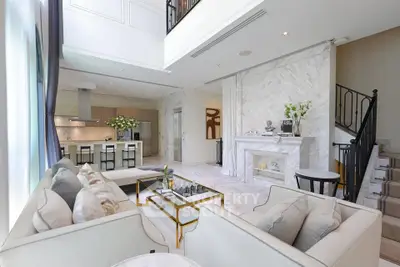 Luxurious open-plan living room with elegant decor and modern kitchen in a spacious apartment.