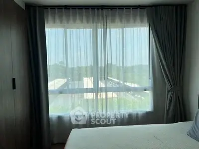 Bright bedroom with large window and elegant curtains