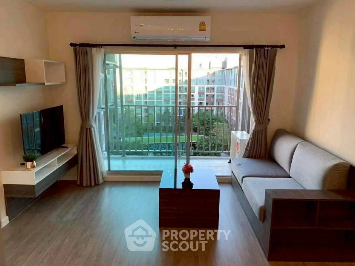 Modern living room with balcony view, featuring sleek furniture and natural light.
