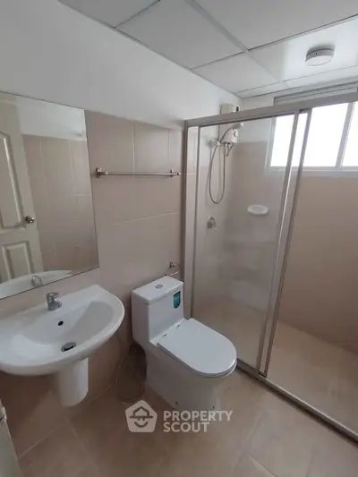 Modern bathroom with glass shower enclosure and sleek fixtures in a contemporary home.