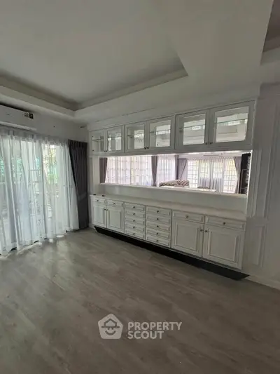 Spacious living room with elegant built-in cabinets and large windows for natural light.