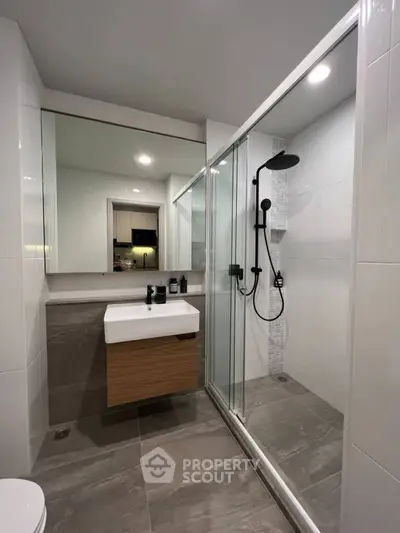 Modern bathroom with sleek shower and stylish vanity in contemporary apartment.