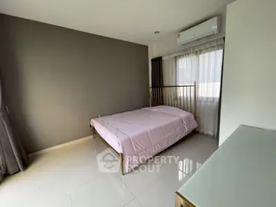 Modern bedroom with sleek design and natural light, featuring a comfortable bed and air conditioning.
