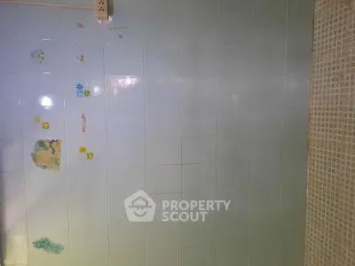Simple bathroom with light blue tiles and decorative stickers