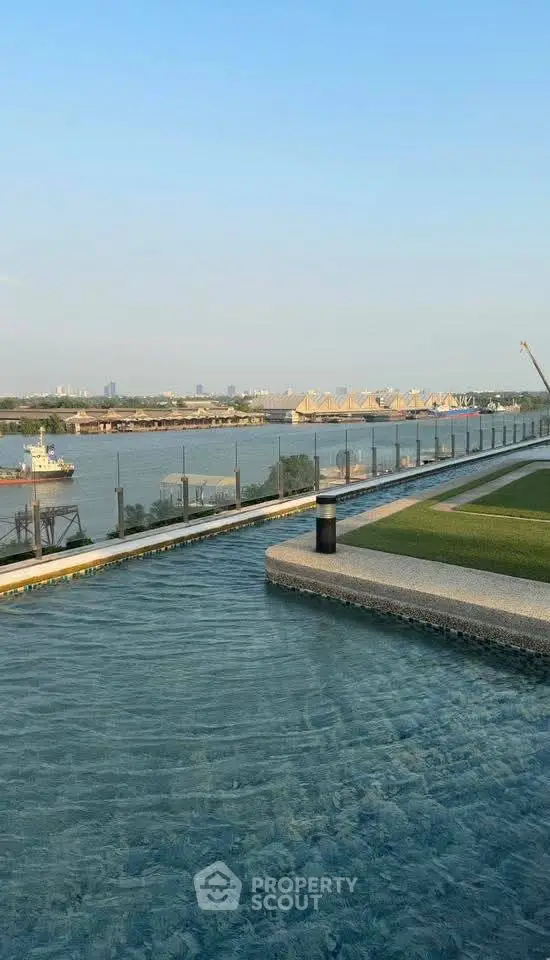 Luxurious rooftop pool with stunning waterfront view and modern glass railing.